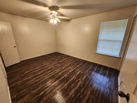a living room with wooden floors and a ceiling fan