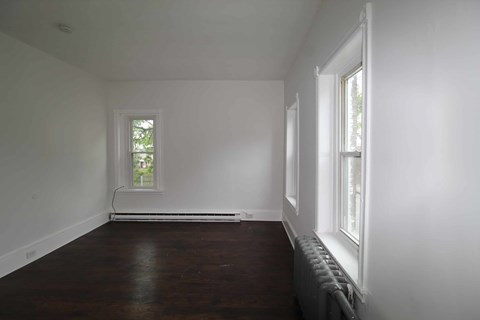A room with a window and a radiator on the wall.