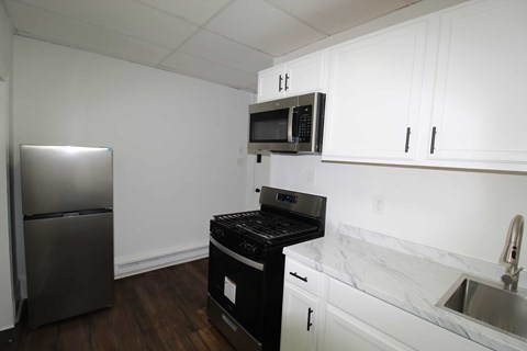 A kitchen with a black stove top oven and microwave.