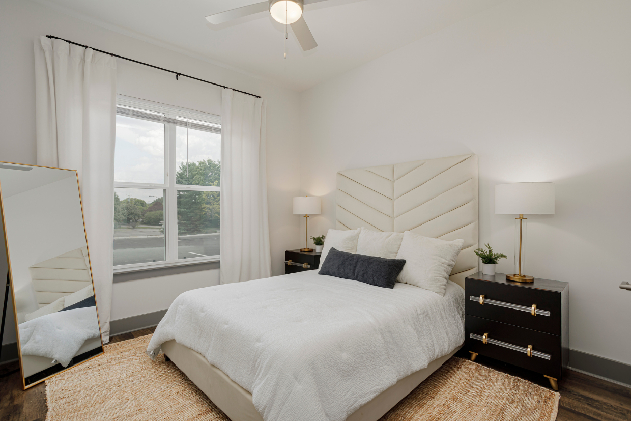 a bedroom with a large white bed and a large window