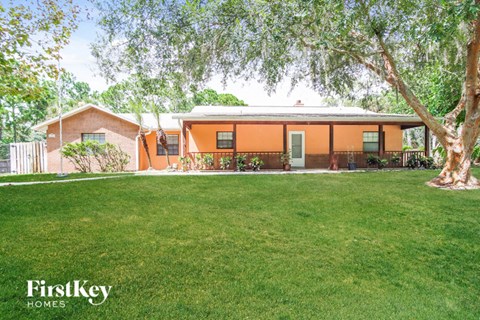 A house with a lawn and trees in front of it.