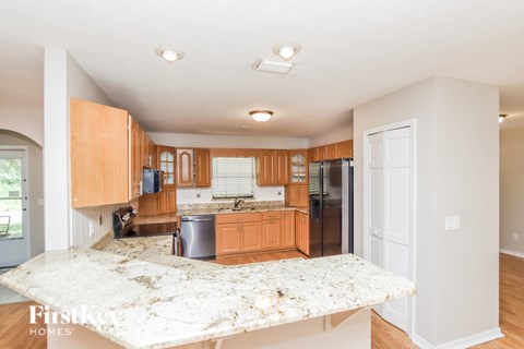 A kitchen with wooden cabinets and a granite countertop.