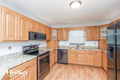 A kitchen with wooden cabinets and a granite countertop.