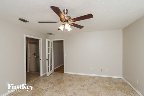 A room with a ceiling fan and a tile floor.