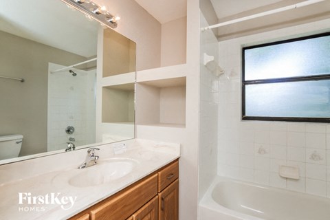 A bathroom with a white sink and a tub.
