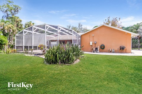 A house with a green lawn and a glass house attached to it.