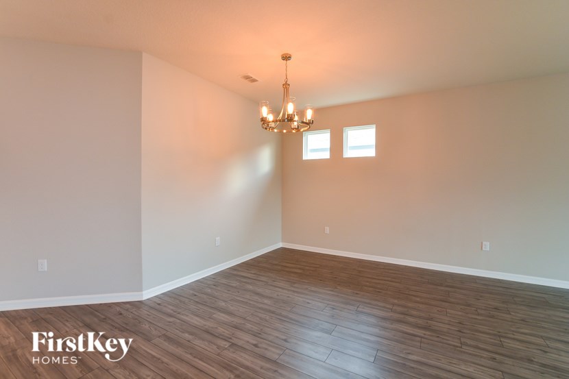 A room with wooden flooring and a chandelier.