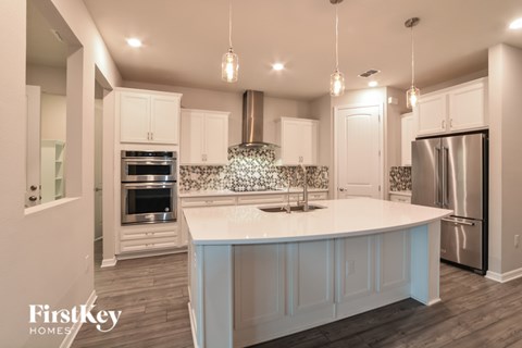 A modern kitchen with a large island and stainless steel appliances.