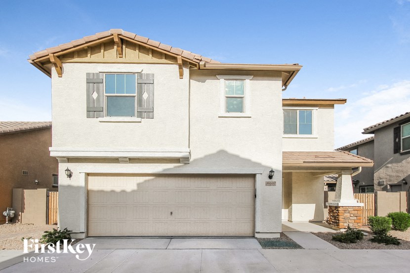 a white house with a garage door in front of it