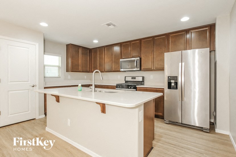 an updated kitchen with stainless steel appliances and white countertops