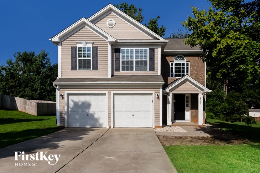 a tan house with a white garage door