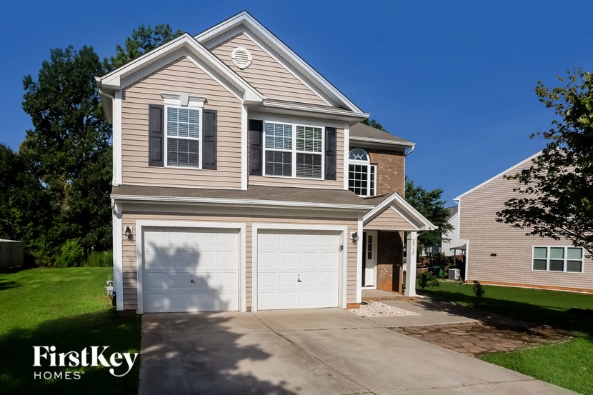 a tan house with a white garage door