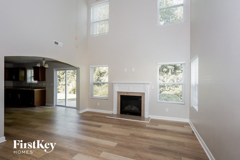 a living room with a fireplace and wooden floors