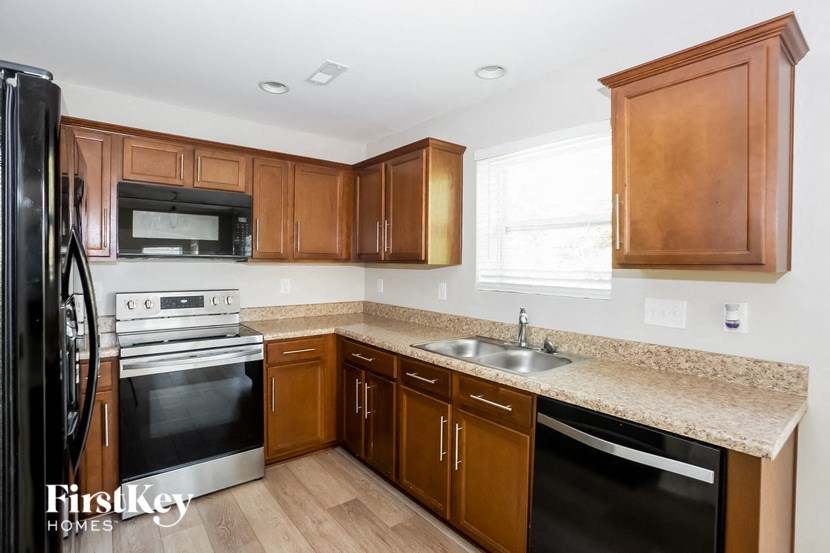 a kitchen with wooden cabinets and black appliances and granite counter tops
