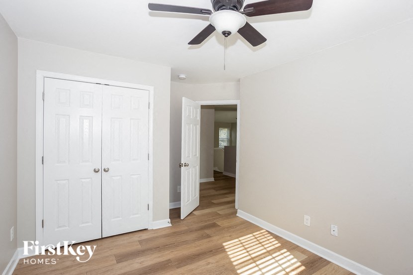 a bedroom with two closets and a ceiling fan