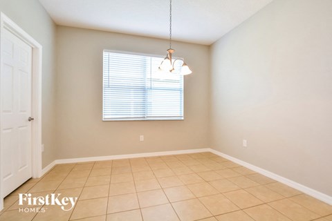a dining room with a large window and a tiled floor