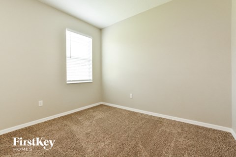 the upstairs bedroom with carpet and a window