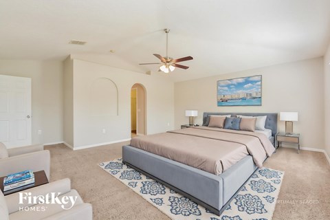 A bedroom with a large bed and a painting on the wall.