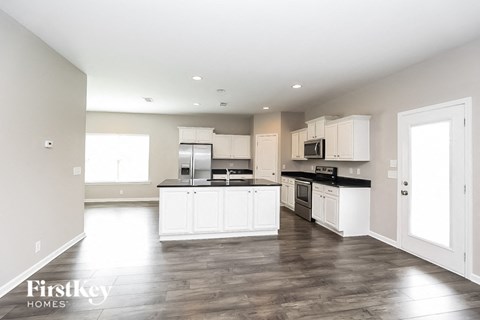 a large kitchen with white cabinets and stainless steel appliances