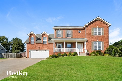A brick house with a garage and a well-kept lawn.
