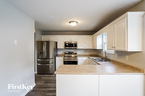 A kitchen with white cabinets and a wooden island.