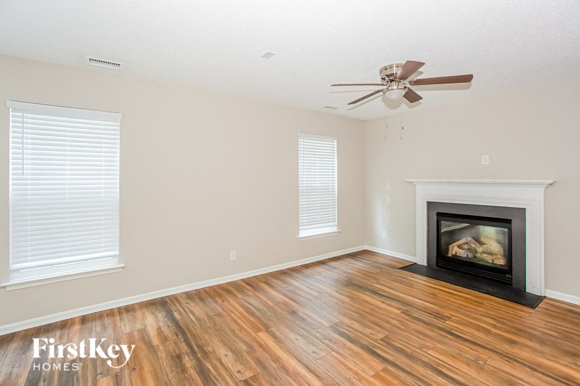 a living room with a wood floor and a fireplace