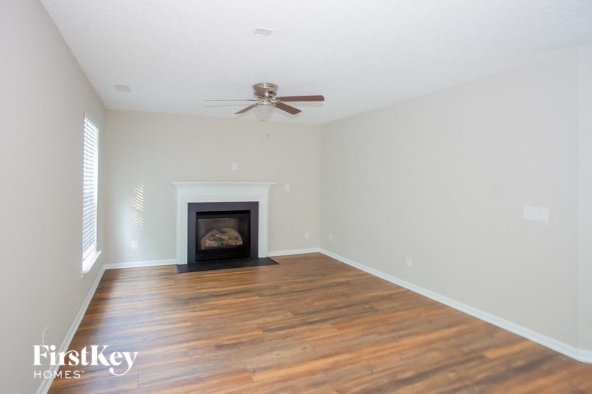 the living room with wood flooring and a fireplace