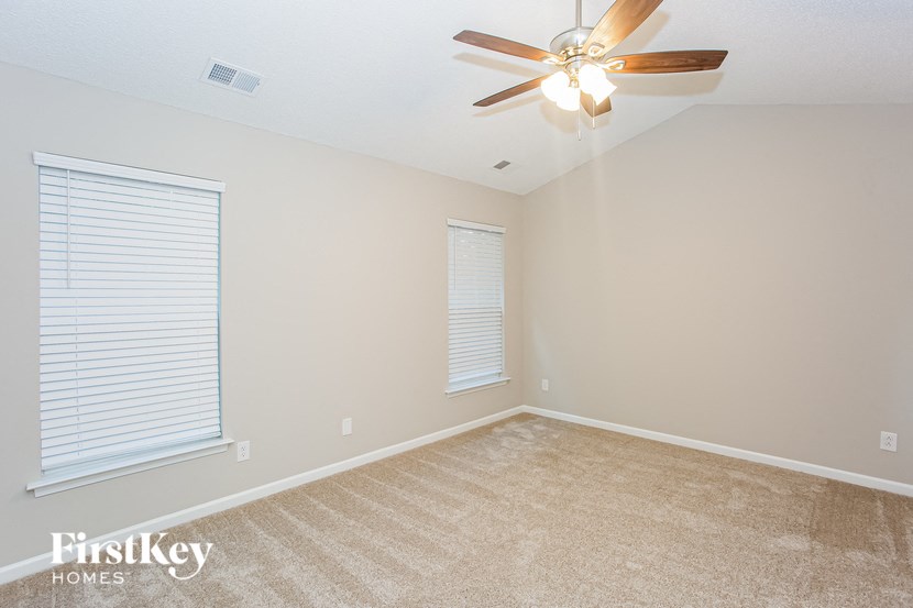 a bedroom with a ceiling fan and a window