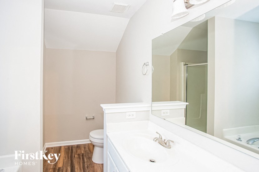 a bathroom with a large mirror and a sink and a toilet