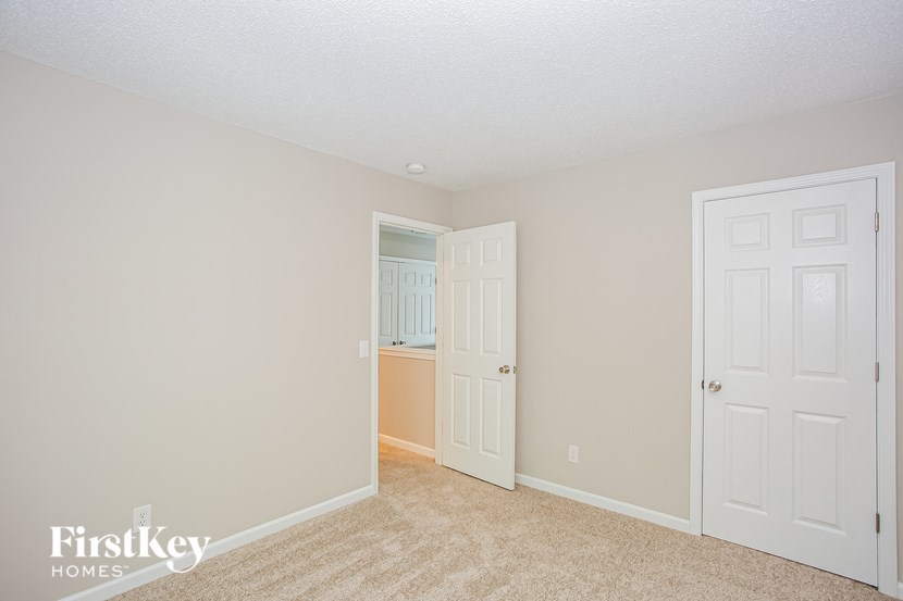 a bedroom with two closets and a door to a bathroom