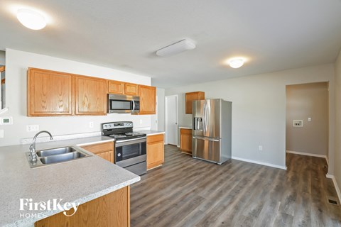 A kitchen with wooden cabinets and a grey counter top.