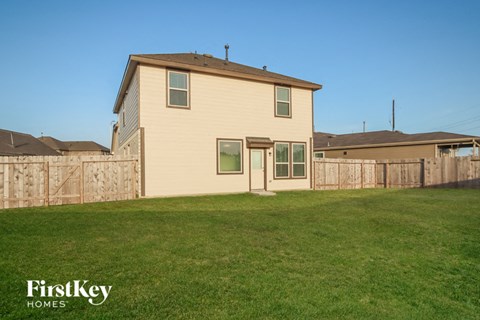 A house with a fence and a grassy yard.