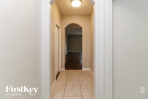a hallway with an archway and a tiled floor