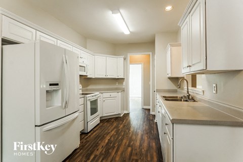 a kitchen with white cabinets and white appliances