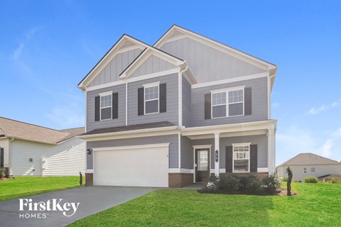 a gray house with a lawn in front of it