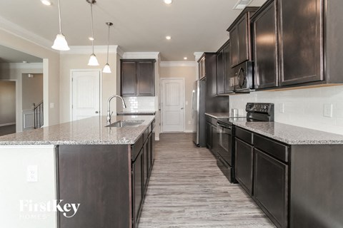 a kitchen with dark wood cabinets and granite counter tops and a sink