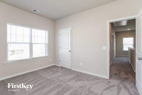 a bedroom with a hallway and a door and a window