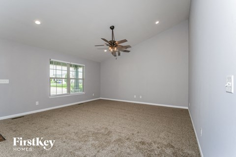 a room with carpet and a ceiling fan