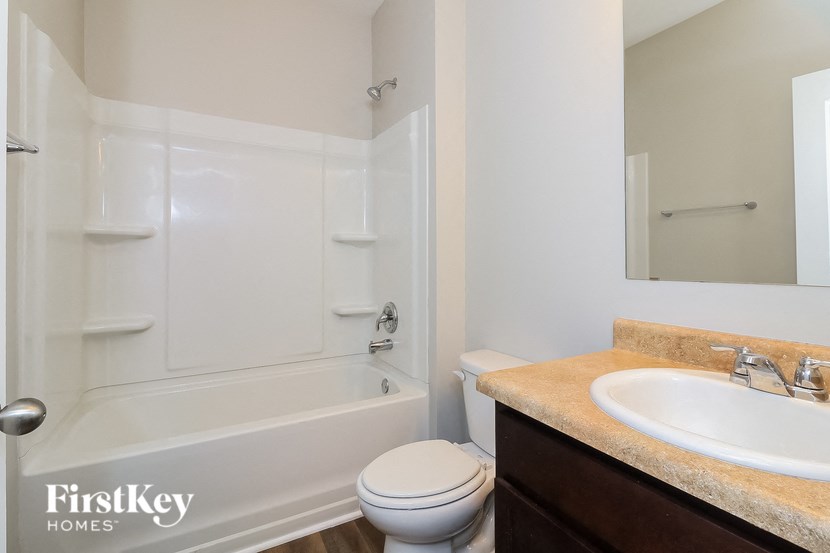 A white bathroom with a toilet, sink and bathtub.