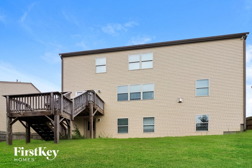 A two-story house with a deck and a balcony.