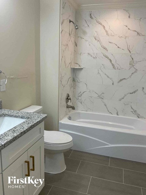 a bathroom with a toilet and a tub and a sink