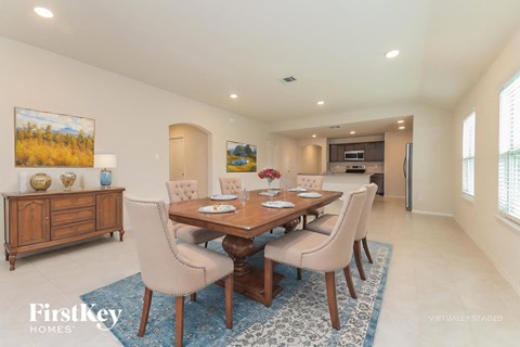A dining room with a wooden table and chairs.