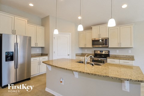 A kitchen with a granite countertop and stainless steel appliances.