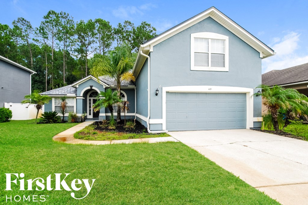 a blue house with a blue garage door and a green lawn