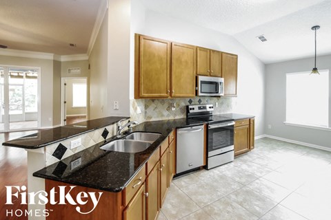 a kitchen with wooden cabinets and granite counter tops