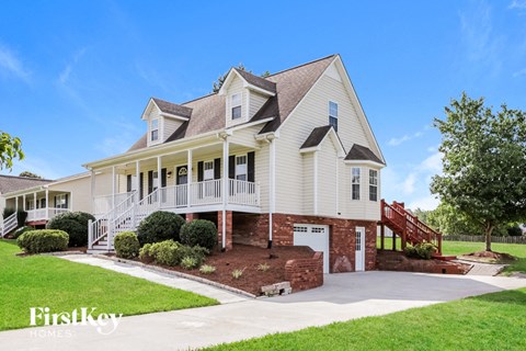 a white house with a large porch and a staircase