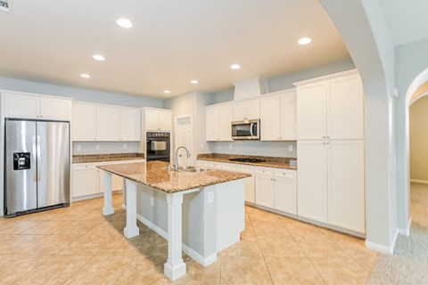 A kitchen with a table and cabinets.