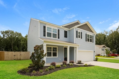 A house with a grey and yellow exterior and a white garage door.