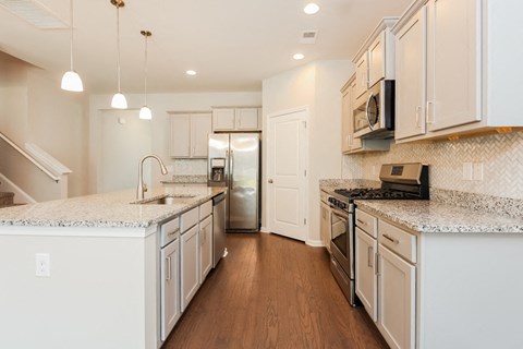 A kitchen with white cabinets and a stainless steel refrigerator.
