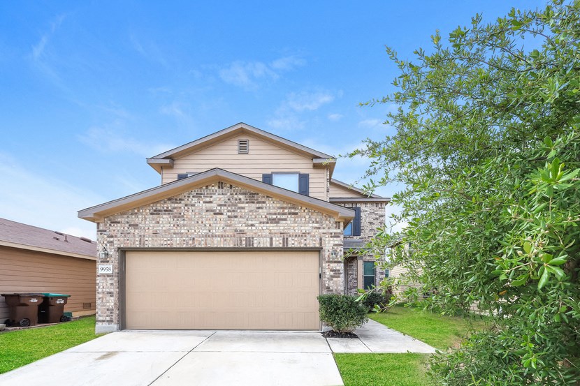 A house with a garage door and a driveway.